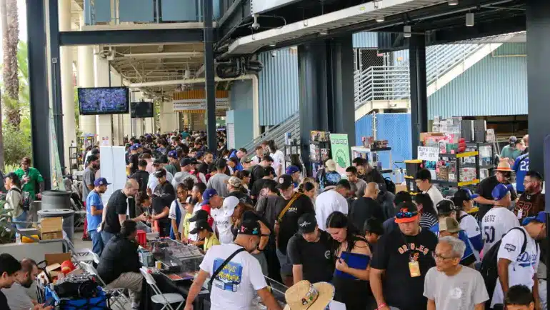 Crowded card show with collectors browsing vendor tables at a trading card convention