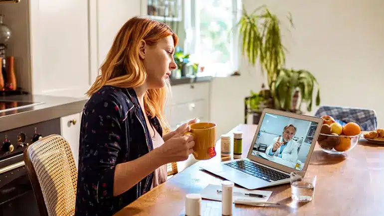 Patient on a telehealth consultation with a functional medicine provider at home, part of an integrative care program with ongoing payments