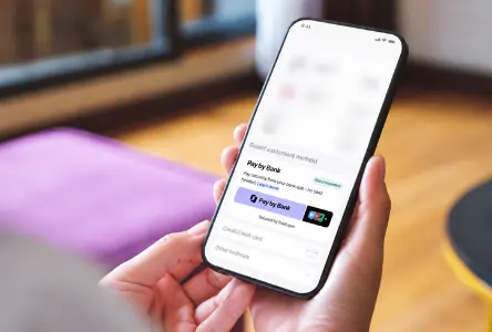 Client paying for a high-ticket wellness service directly from their bank account using Pay by Bank on a smartphone