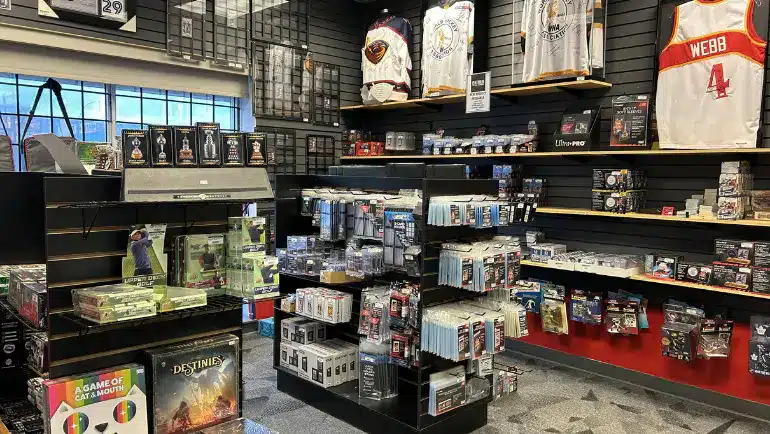 Sports card shop with shelves of sealed wax boxes, graded cards and signed jerseys on display